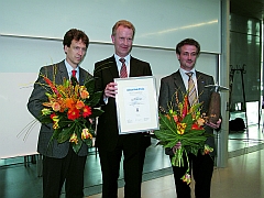 Gerhard Jansen, Geschäftsführer der regionalen Wirtschaftsfördergesellschaft übergibt den „Lilienthal-Preis“ an Dr. Mario Münzberg (l.) und Dr. Holger Vogel von Carl Zeiss Optronics